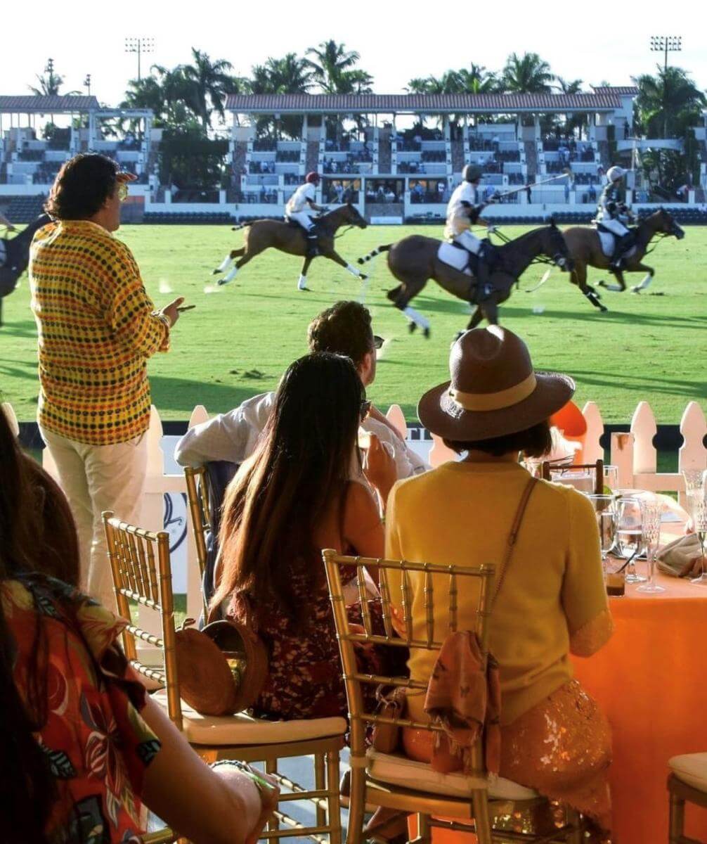 Wide view of a polo field with riders and horses