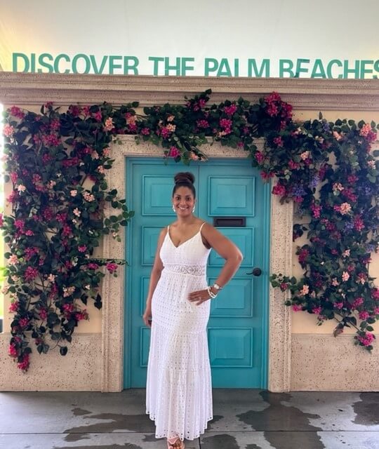Tosha Williams under the Palm Beaches sign