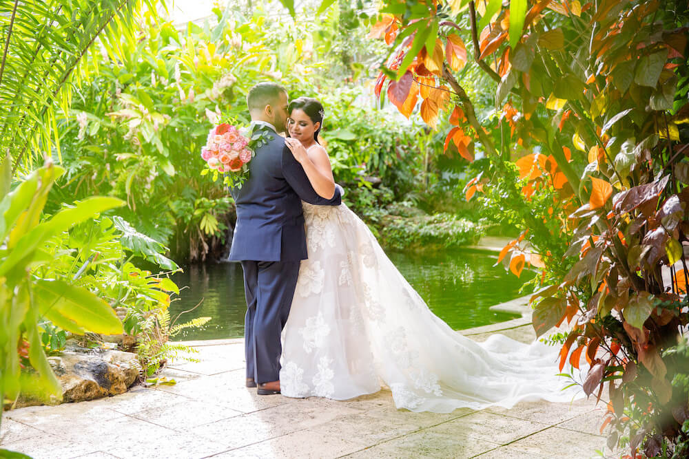 Bride and groom embracing surrounded by a garden