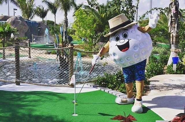 Photo by user puttnaround, caption reads Putty says it’s the perfect mini golf weather today ! Come out and enjoy 36 holes of mini golf in our beautiful botanical gardens! Enjoy refreshing beverages and great music throughout the course!