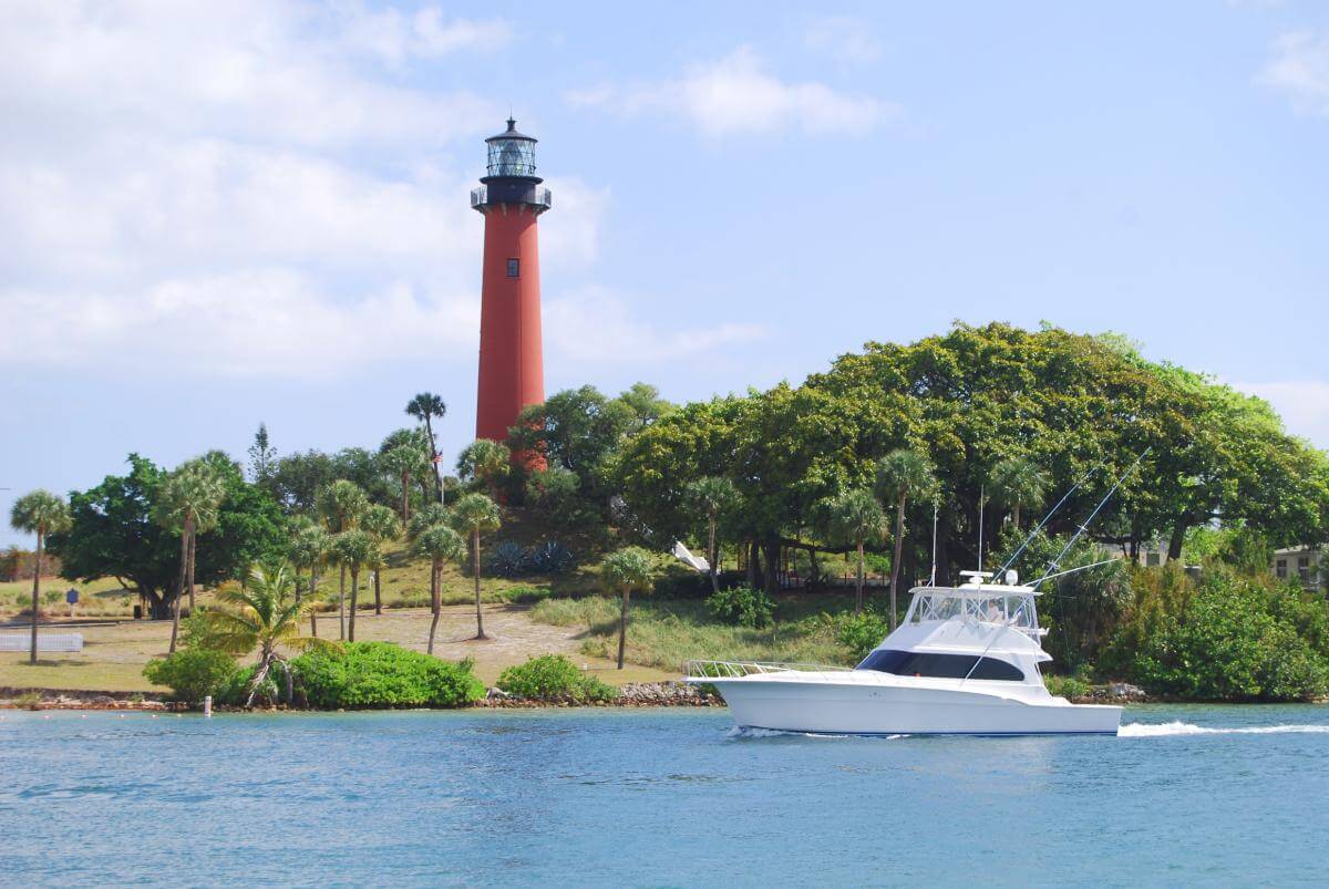 Boat cruising by the Jupiter Inlet Lighthouse