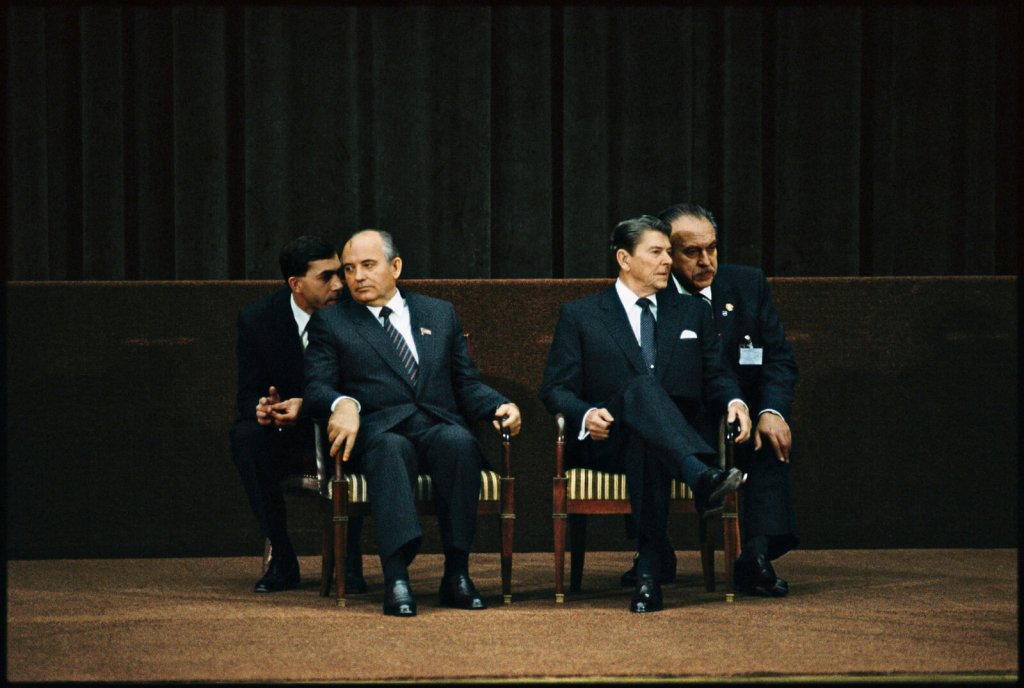 Ronald Reagan, Mikhail Gorbachev e dois outros homens sentados em cadeiras