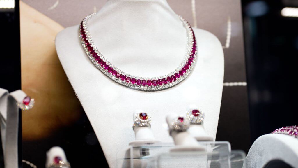 Uma impressionante exibição de joias finas com um colar de safira rosa e diamantes, brincos e anéis em um busto de manequim branco
