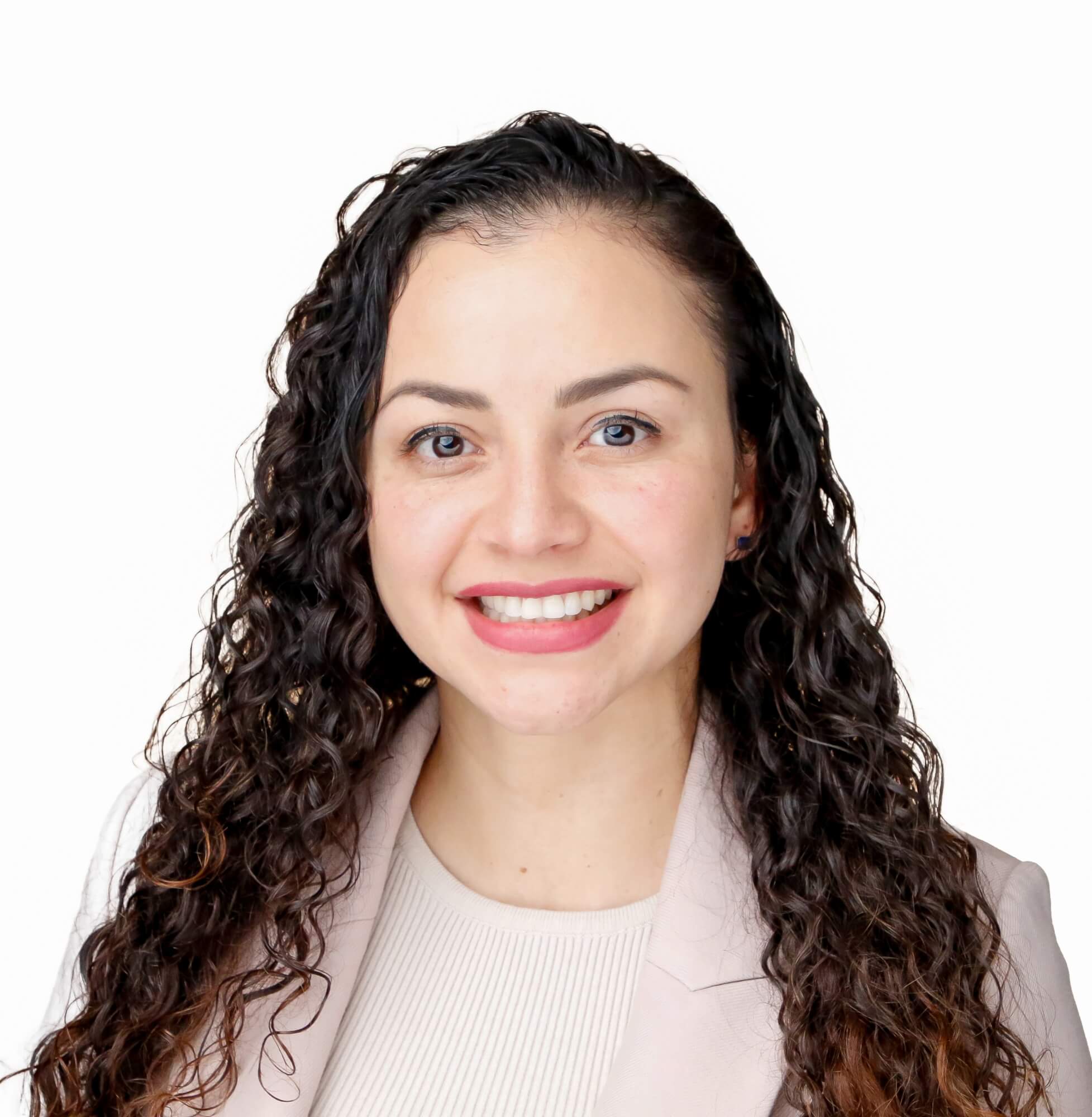 A woman with long, curly dark hair smiles warmly at the camera