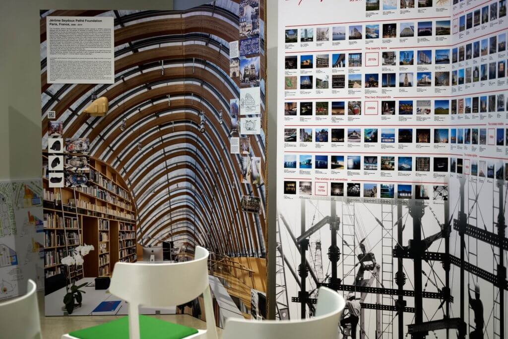 Eine Ausstellung mit architektonischen Modellen und Fotografien innovativer Gebäude, darunter ein auffallend geschwungener Glasbau