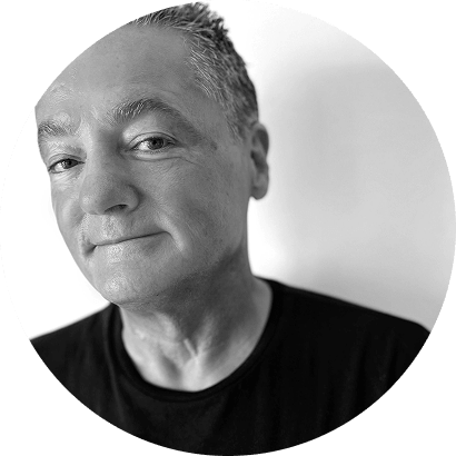 A man with short, gray hair and a slight smile looks directly at the camera