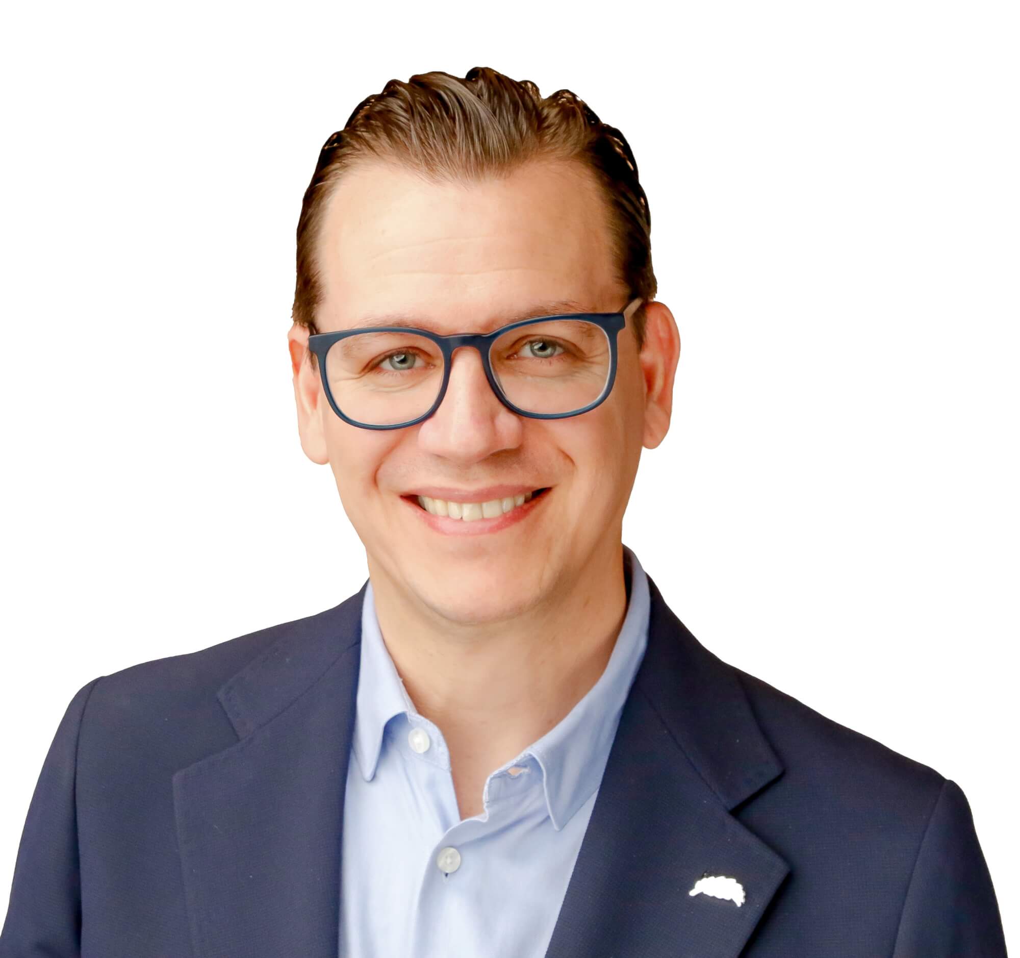 A man with glasses and a smile, wearing a dark suit jacket over a light blue shirt