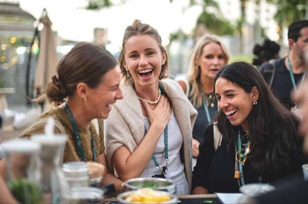 A group of women are laughing and enjoying each other's company at an outdoor gathering
