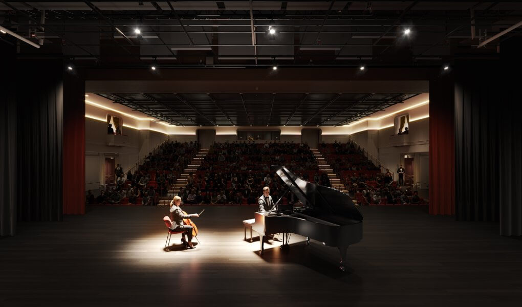 A pianist and cellist perform a duet on a dimly lit stage in front of an audience