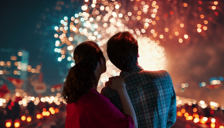 Pareja feliz y enamorada viendo fuegos artificiales.