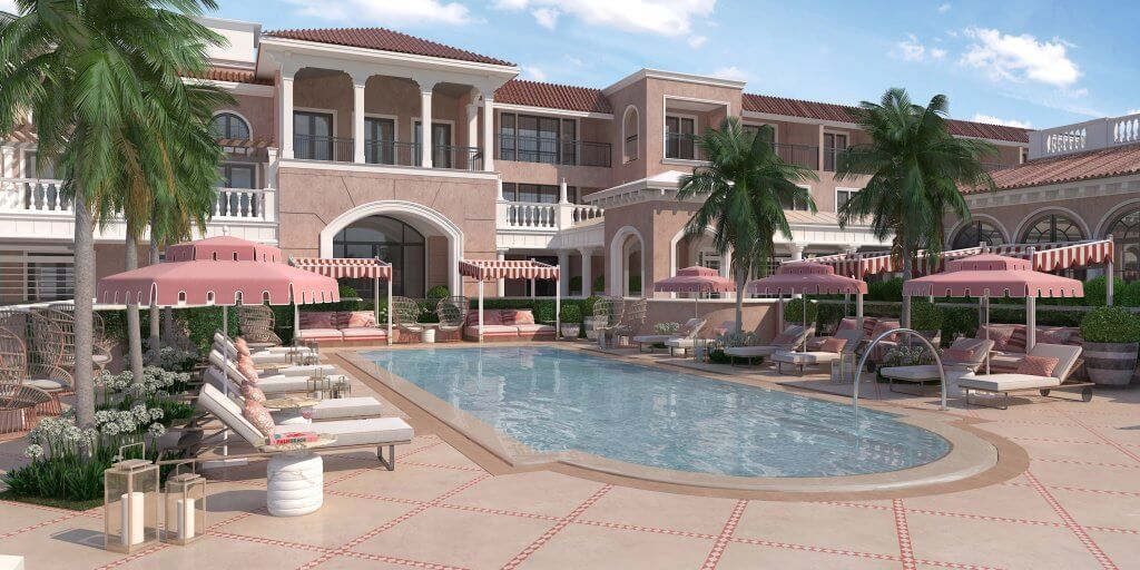 Ce complexe luxueux dispose d'une grande piscine entourée de parasols roses et de chaises longues, avec en toile de fond une élégante architecture de style méditerranéen et des palmiers.