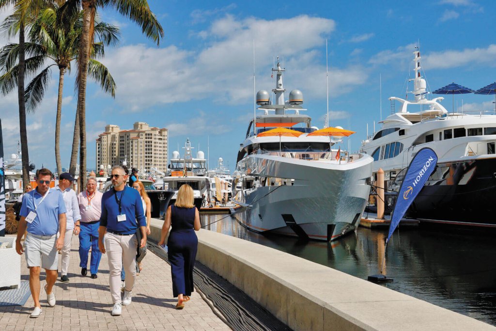 um grupo de pessoas caminhando em uma doca com barcos