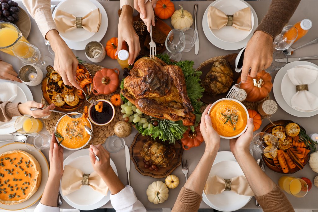 Happy family having dinner at festive table on Thanksgiving Day