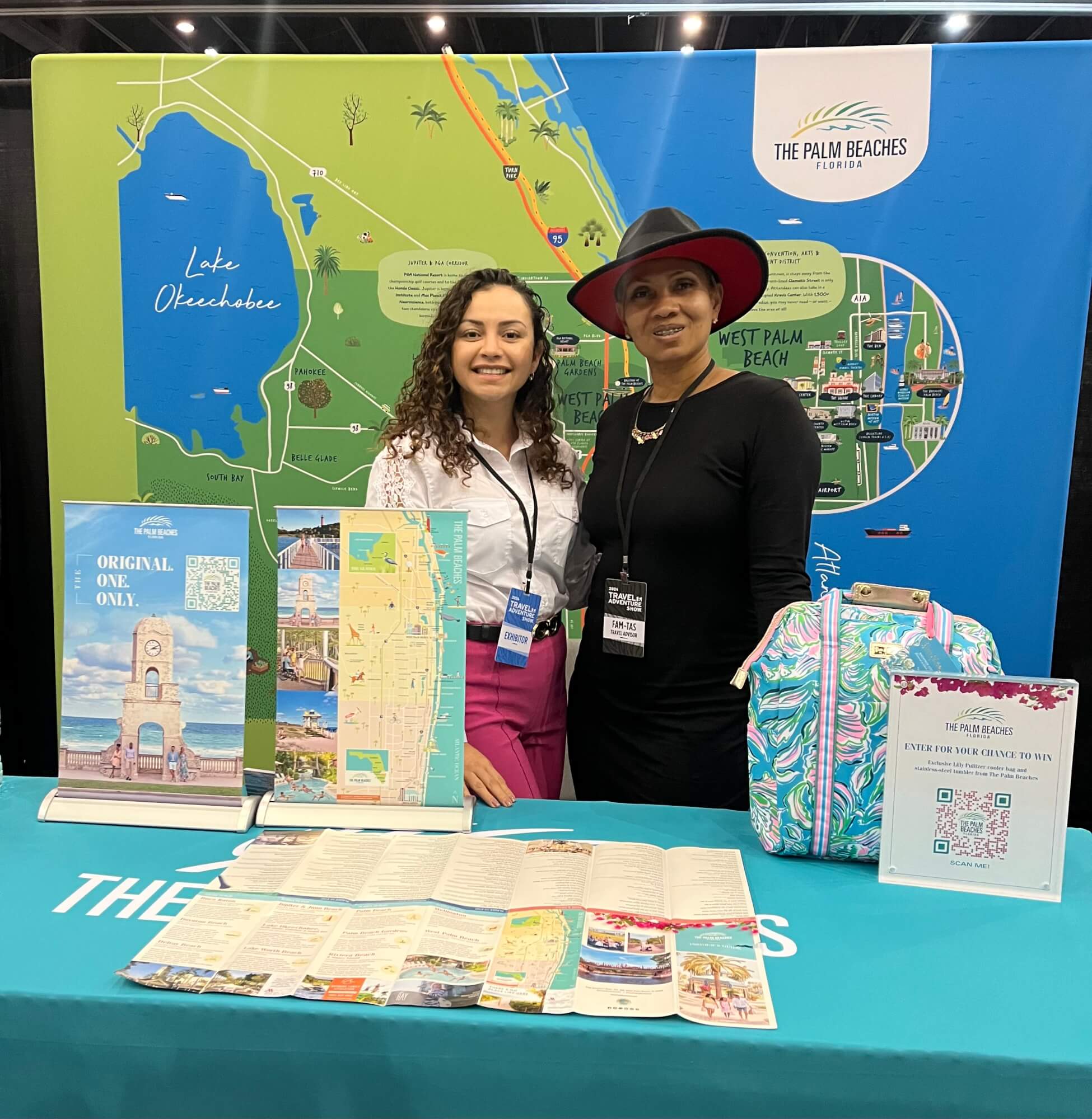 Two women standing at a travel trade show booth for The Palm Beaches