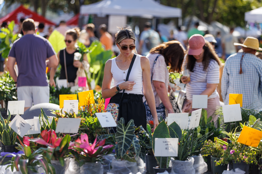 una señora mirando plantas en el West Palm Beach Greenmarket