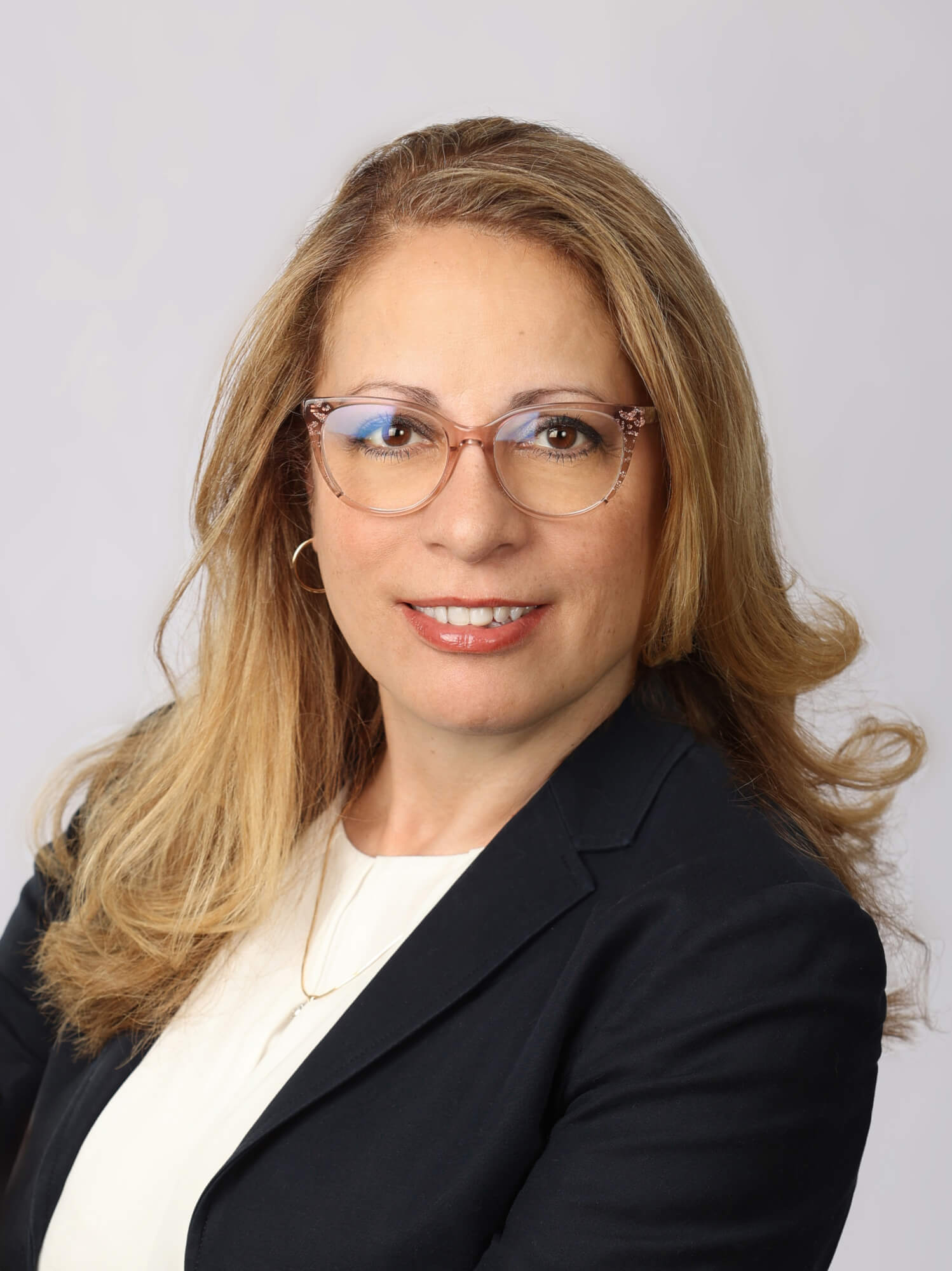 Une femme d'affaires blonde, à lunettes, vêtue d'un blazer foncé