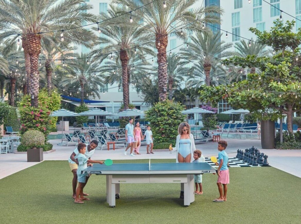 una mujer, un hombre y niños jugando al ping pong en el Hilton West Palm Beach
