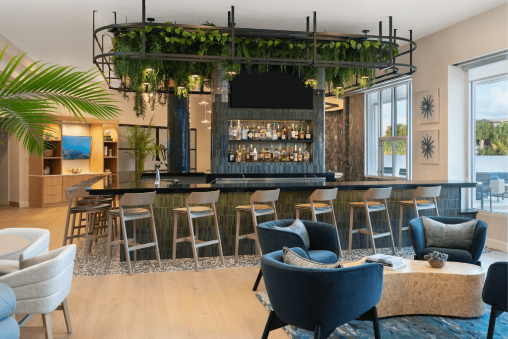 Una elegante zona de descanso interior con bar, cómodos asientos y una exuberante vegetación
