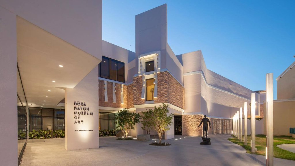 The Boca Raton Museum of Art at dusk, showcasing its modern architecture with illuminated sculptures and pathways