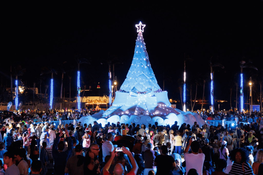 Gente admirando un árbol de Navidad de arena