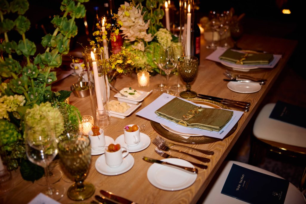 Una mesa elegantemente puesta con exuberantes centros de mesa florales, velas encendidas y vajilla de porcelana fina