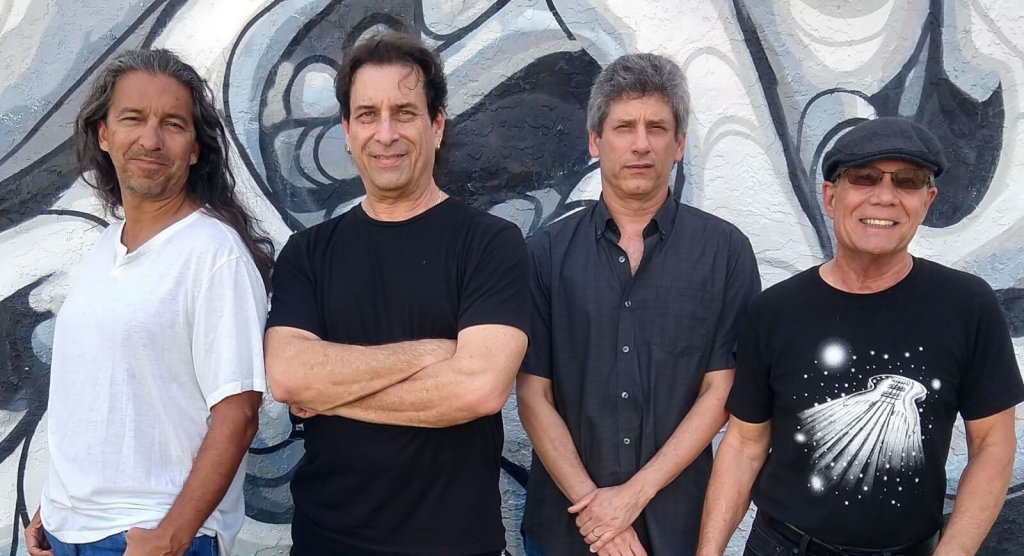 un grupo de personas de pie frente a un muro
